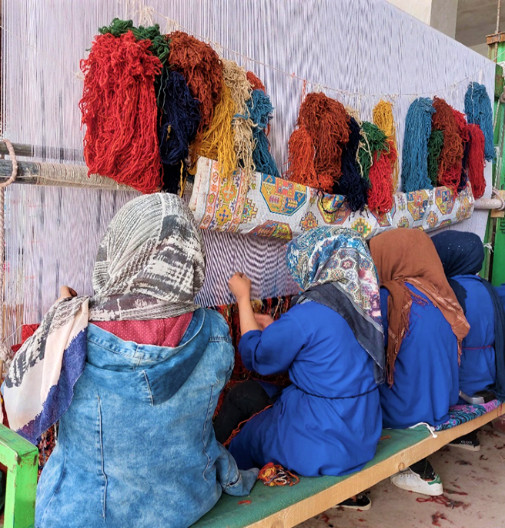 Afghan women hand-weaving carpets in Bamyan, 3/2023. (Twitter photo from @USAIDAfgMD)